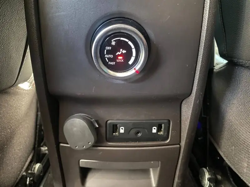 Détail de la console arrière noire du Renault Espace V gris, montrant les commandes de ventilation et prises USB.