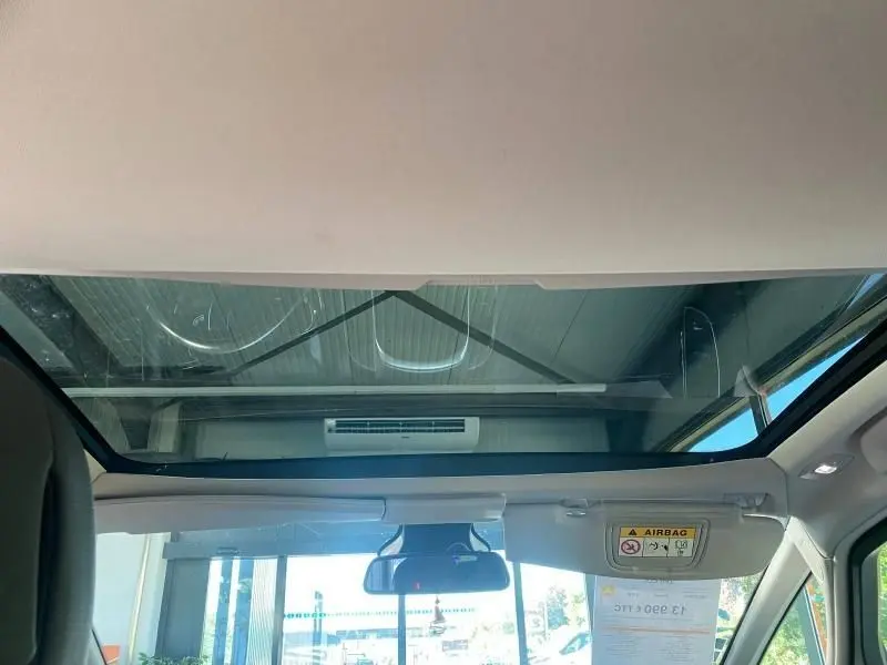 Vue intérieure du toit panoramique Zénith du Renault Espace V gris, mettant en valeur la grande surface vitrée et le pare-soleil.