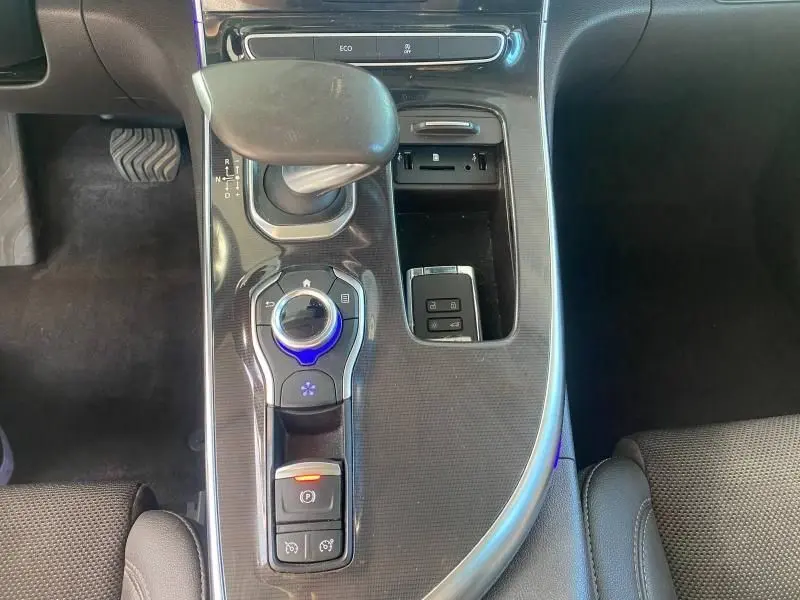 Vue plongeante sur la console centrale noire du Renault Espace V avec levier de boîte automatique et commandes éclairées.
