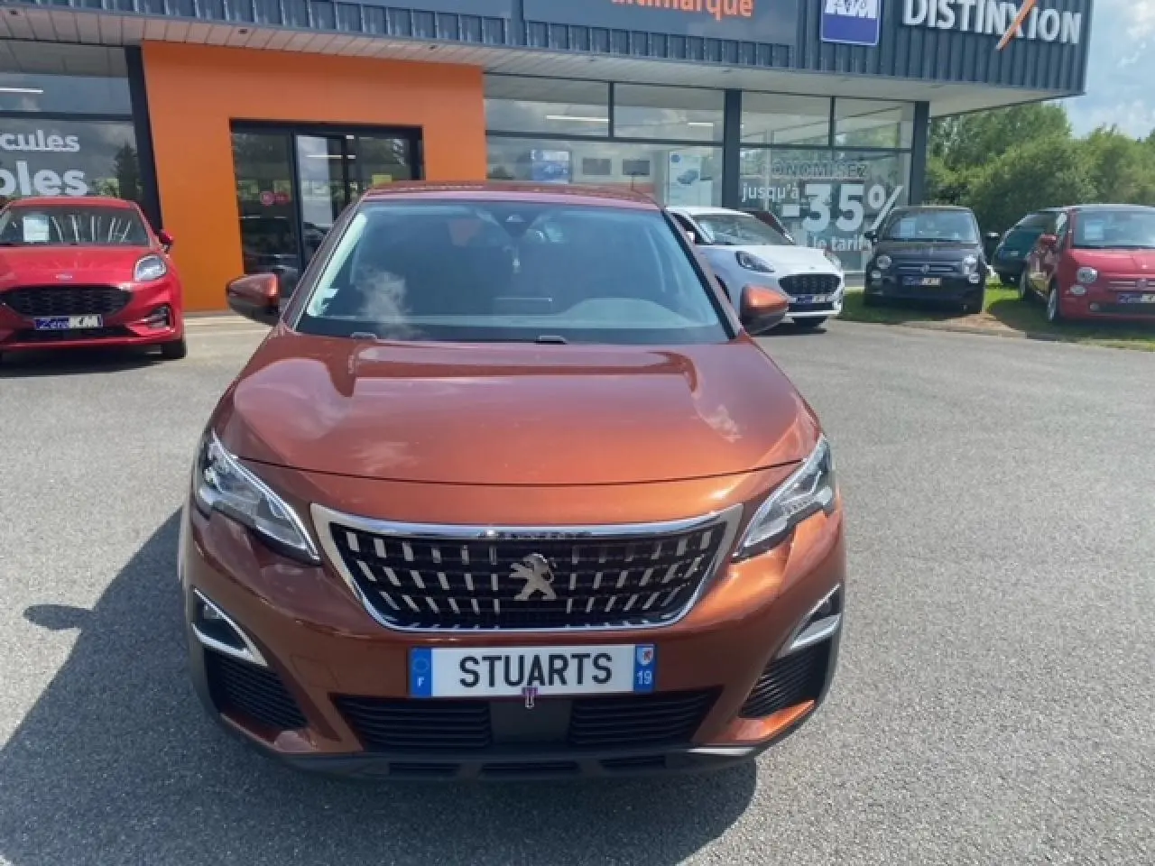 Vue frontale d'un Peugeot 3008 2019 métallisé copper avec calandre chromée et phares LED diurnes.