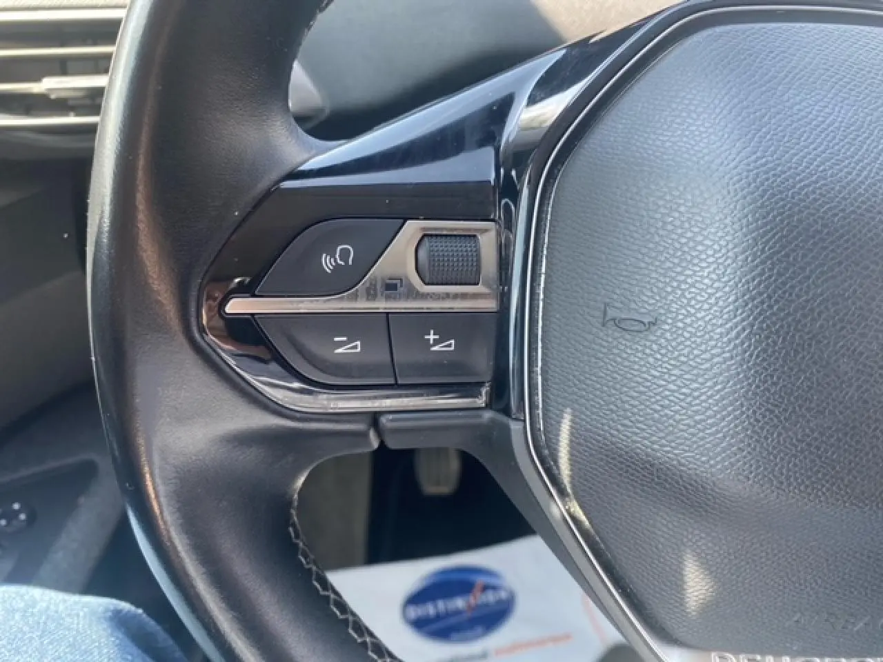 Gros plan sur les commandes audio au volant en cuir noir du Peugeot 3008 2019 finition Active Business.