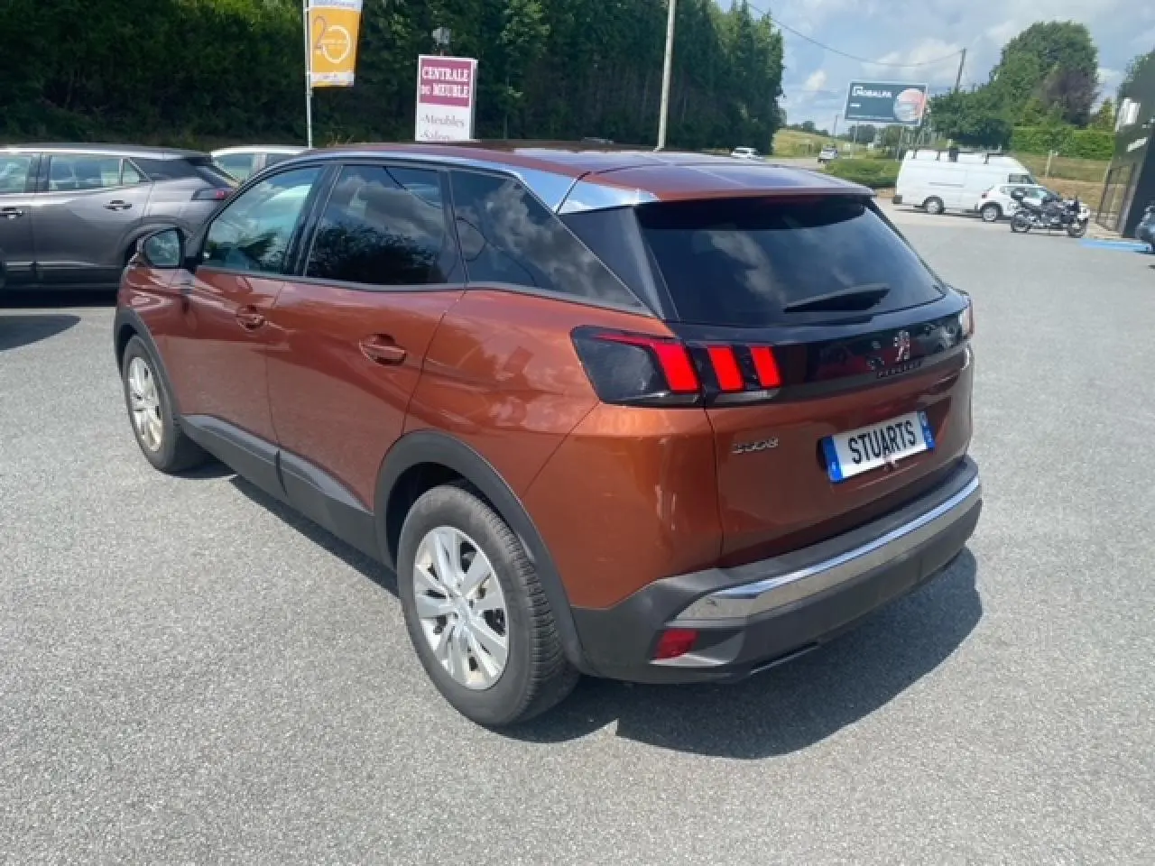 Vue 3/4 arrière droite d'un Peugeot 3008 2019 métallisé copper avec feux arrière à griffes rouges et vitres teintées.