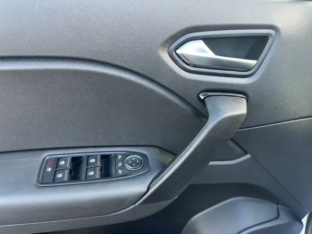Détail de la porte côté conducteur du Renault Captur gris Highland 2024, avec commandes électriques et poignée noire.