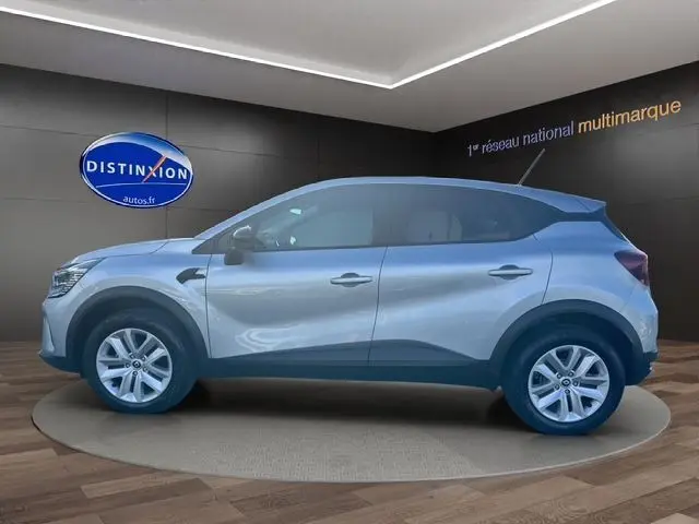 Profil côté gauche du Renault Captur TCE 90 Evolution 2024 en gris Highland, posé en showroom avec jantes alliage visibles.