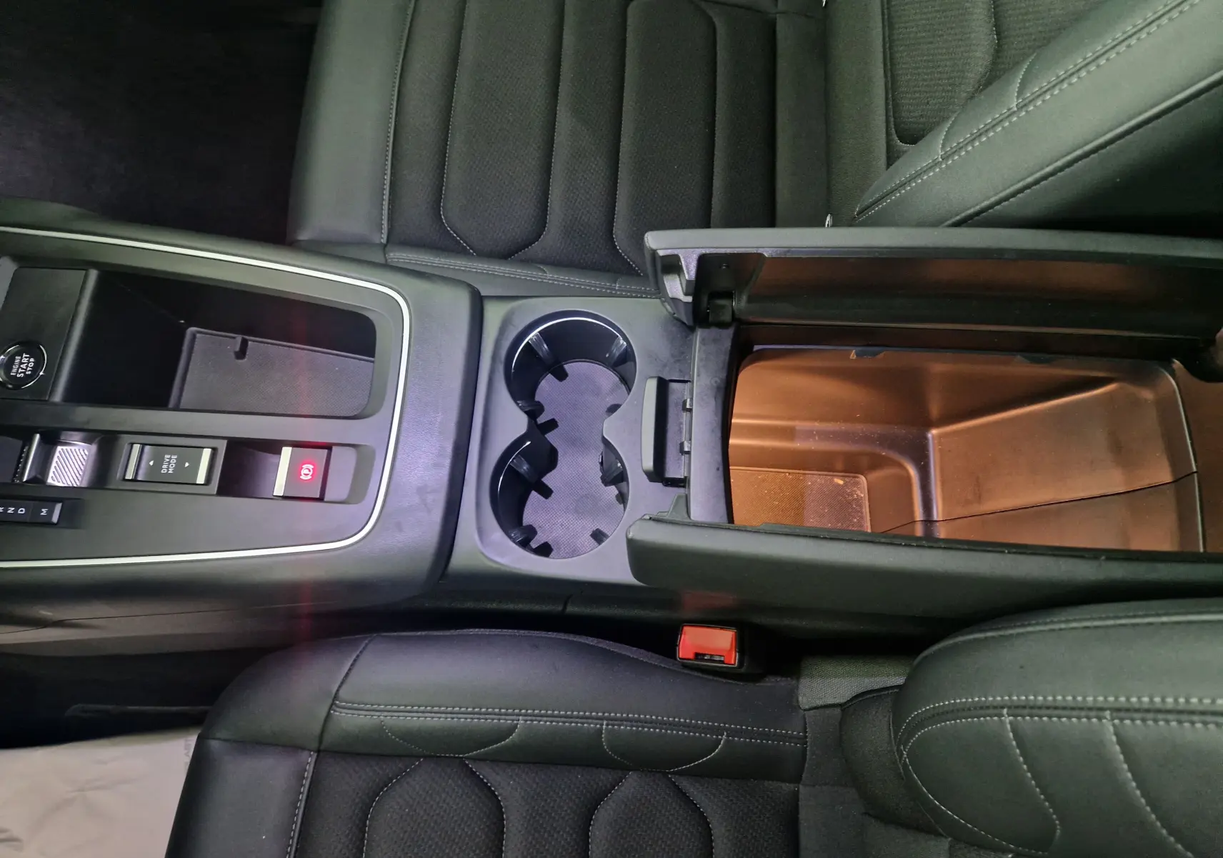 Vue plongeante sur la console centrale du Citroën C5 Aircross gris, avec accoudoir ouvert et sièges en cuir noir.