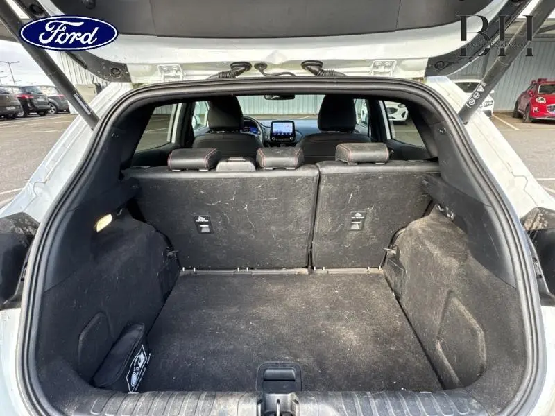 Coffre ouvert d'un Ford Puma blanc Glacier, vue arrière montrant l'espace de chargement et les sièges arrière.