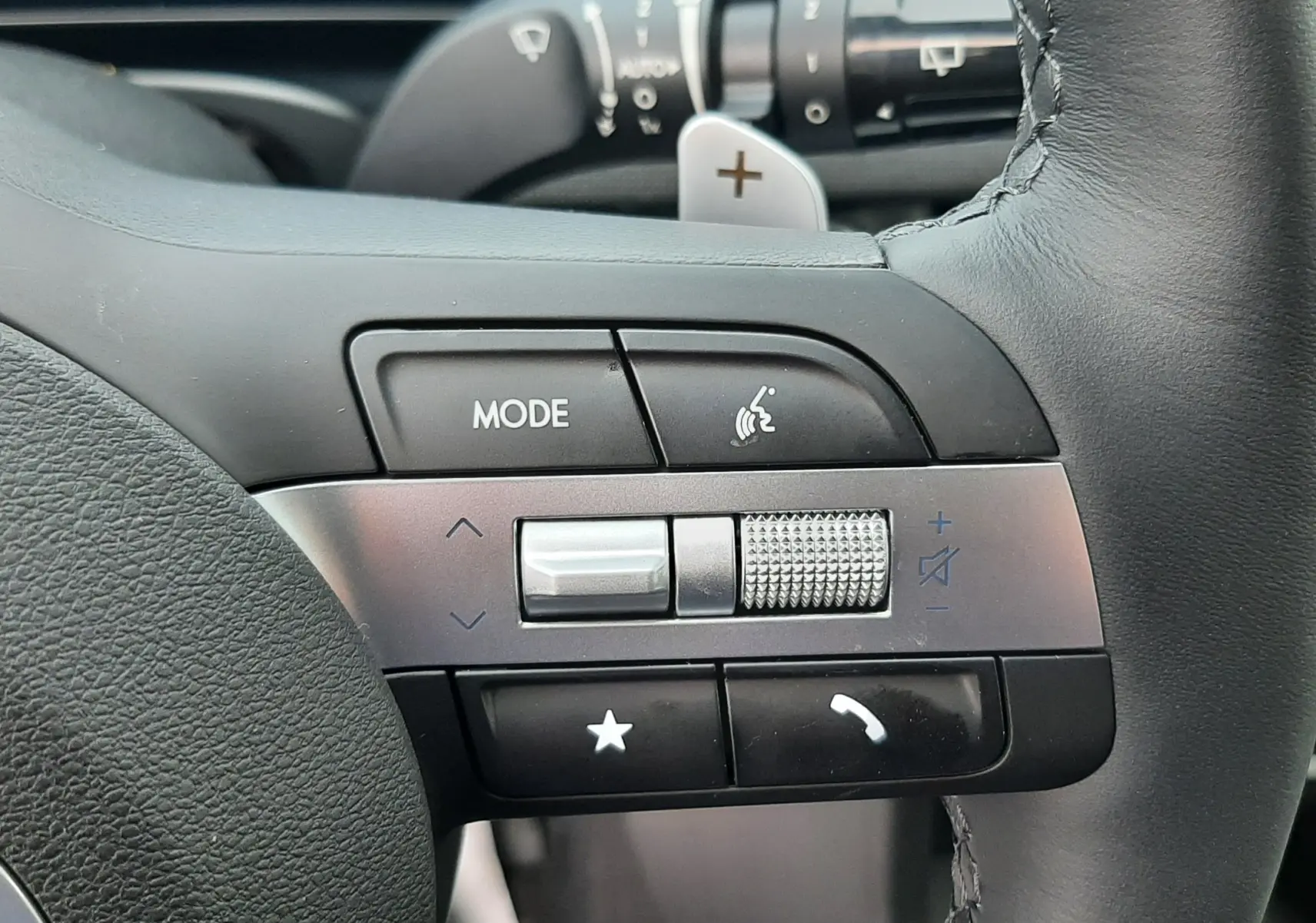 Gros plan sur les commandes multifonctions à gauche du volant du Hyundai Tucson 2025, avec molette de volume et boutons tactiles.