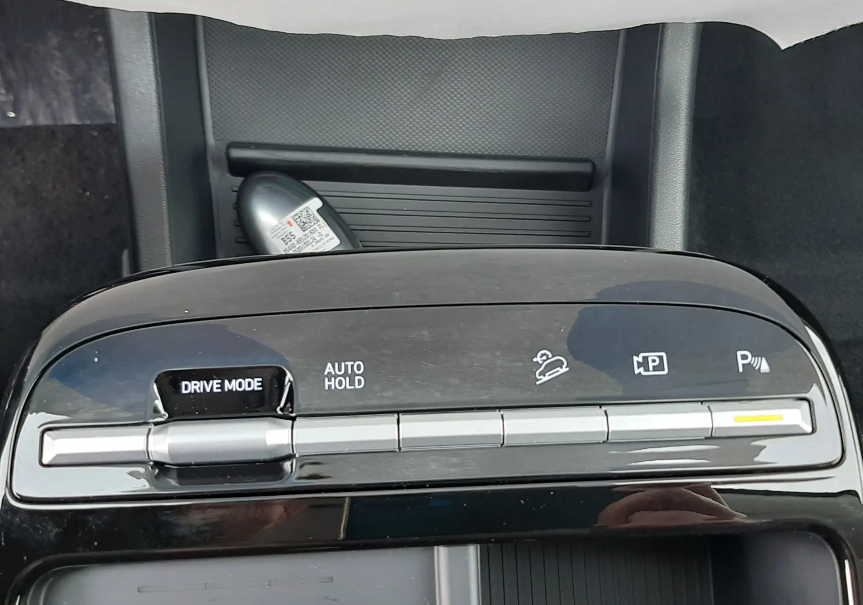 Gros plan sur la console centrale noire du Hyundai Tucson 2025, avec commandes Drive Mode et Auto Hold visibles.
