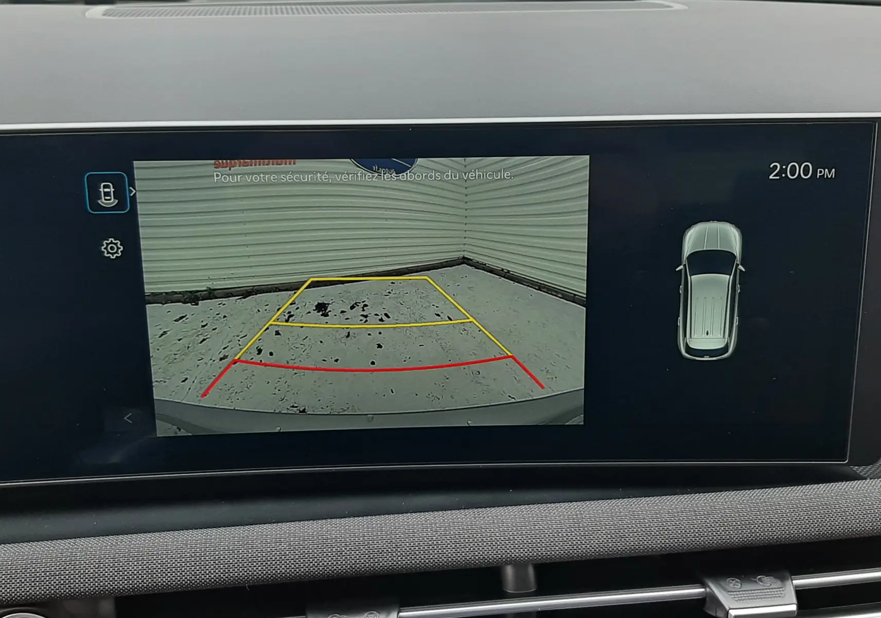 Écran intérieur du Hyundai Tucson 2025 montrant la caméra de recul avec guidage coloré et vue aérienne du véhicule.