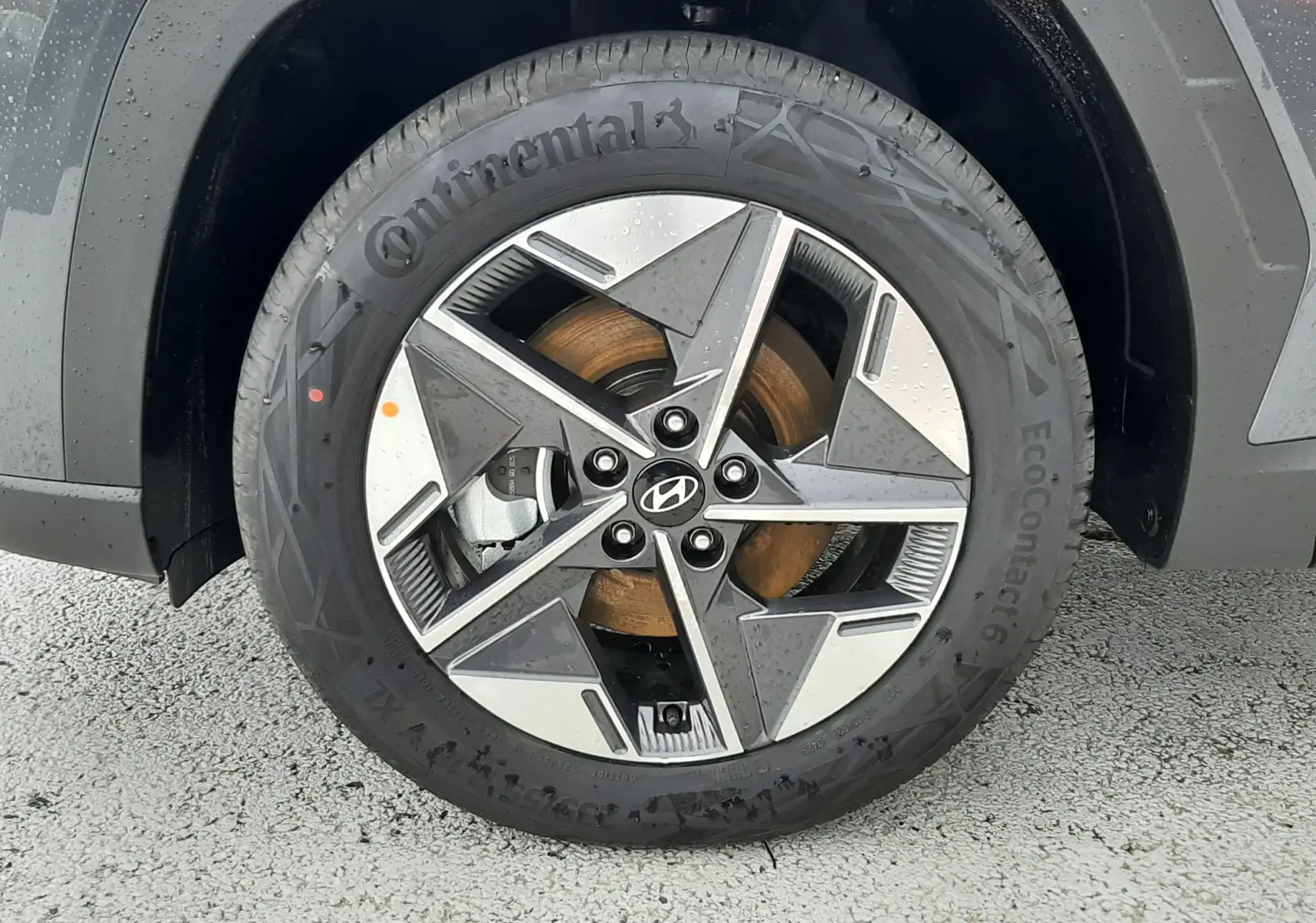 Gros plan sur la roue avant gauche du Hyundai Tucson 2025 gris Ecotronic avec jante alliage bicolore et logo Hyundai central.