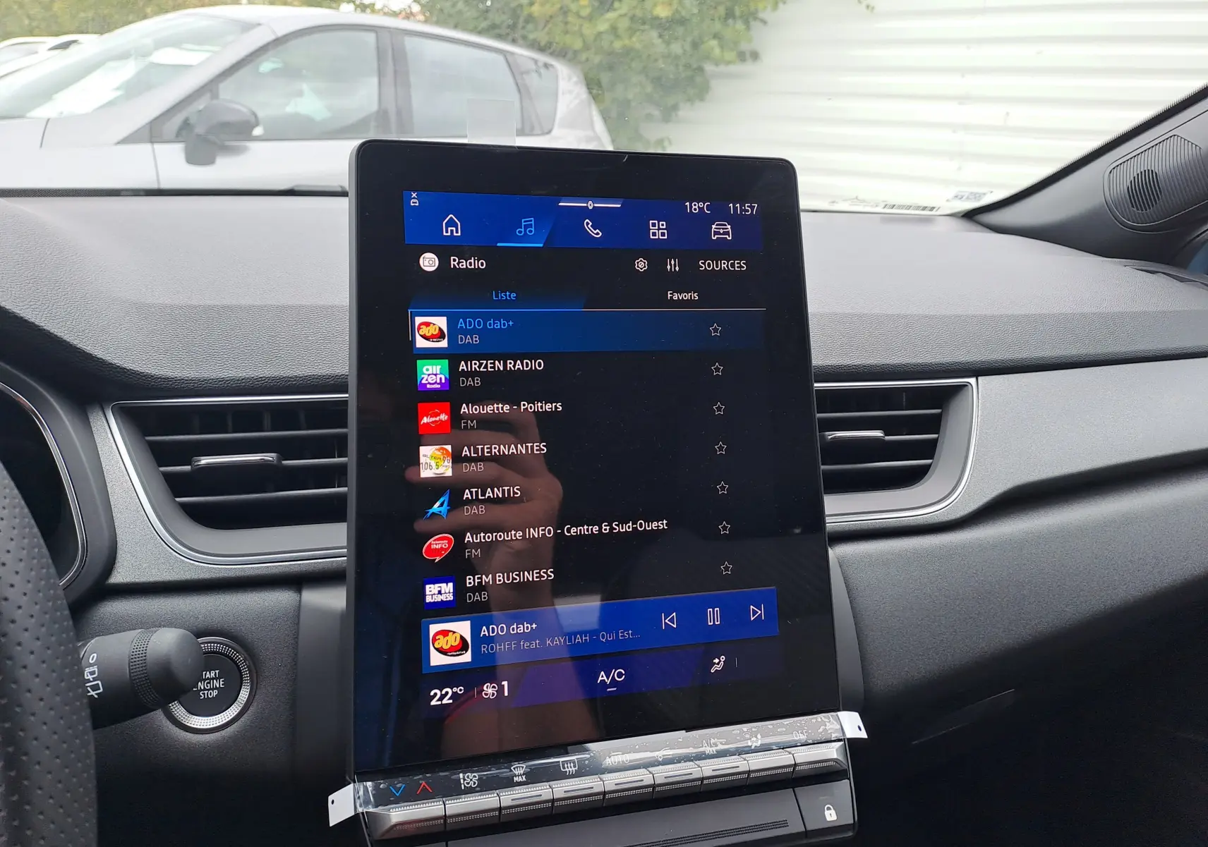 Vue intérieure du tableau de bord de la Renault Symbioz 2025 avec écran tactile central affichant la radio numérique.