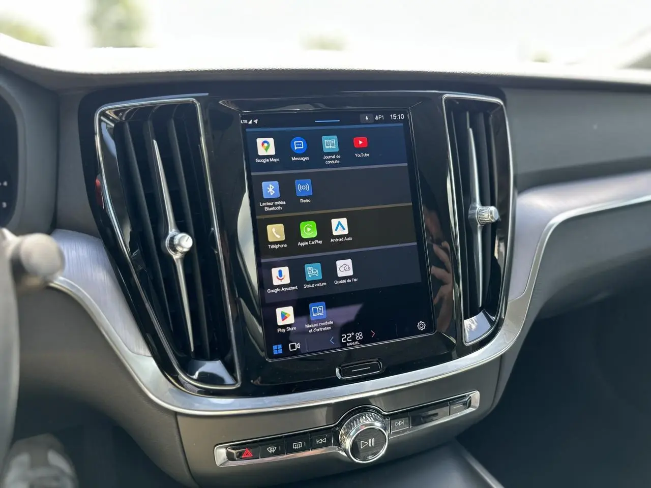 Écran tactile central du tableau de bord du Volvo S60 rouge Fusion 2024 avec commandes multimédia visibles.