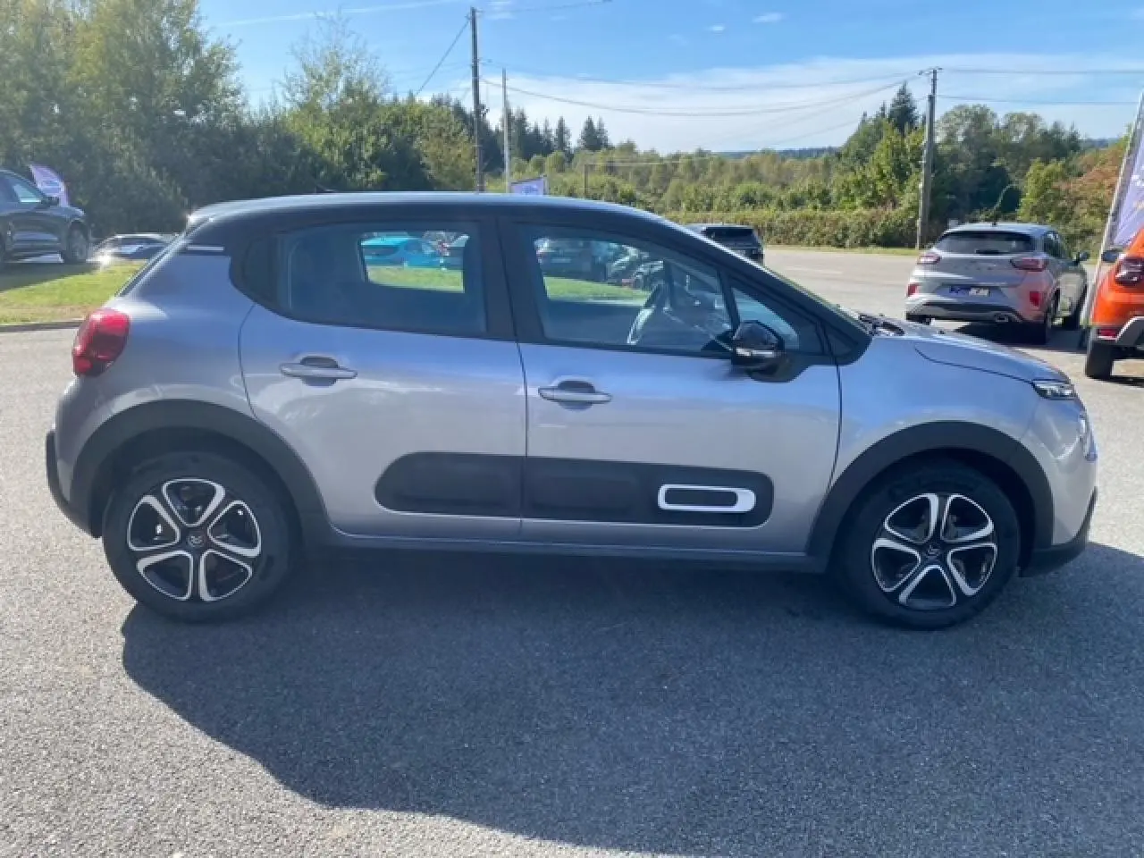 Profil côté gauche d'une Citroën C3 gris Artense métal avec Airbump noir et jantes 16 pouces en extérieur ensoleillé.
