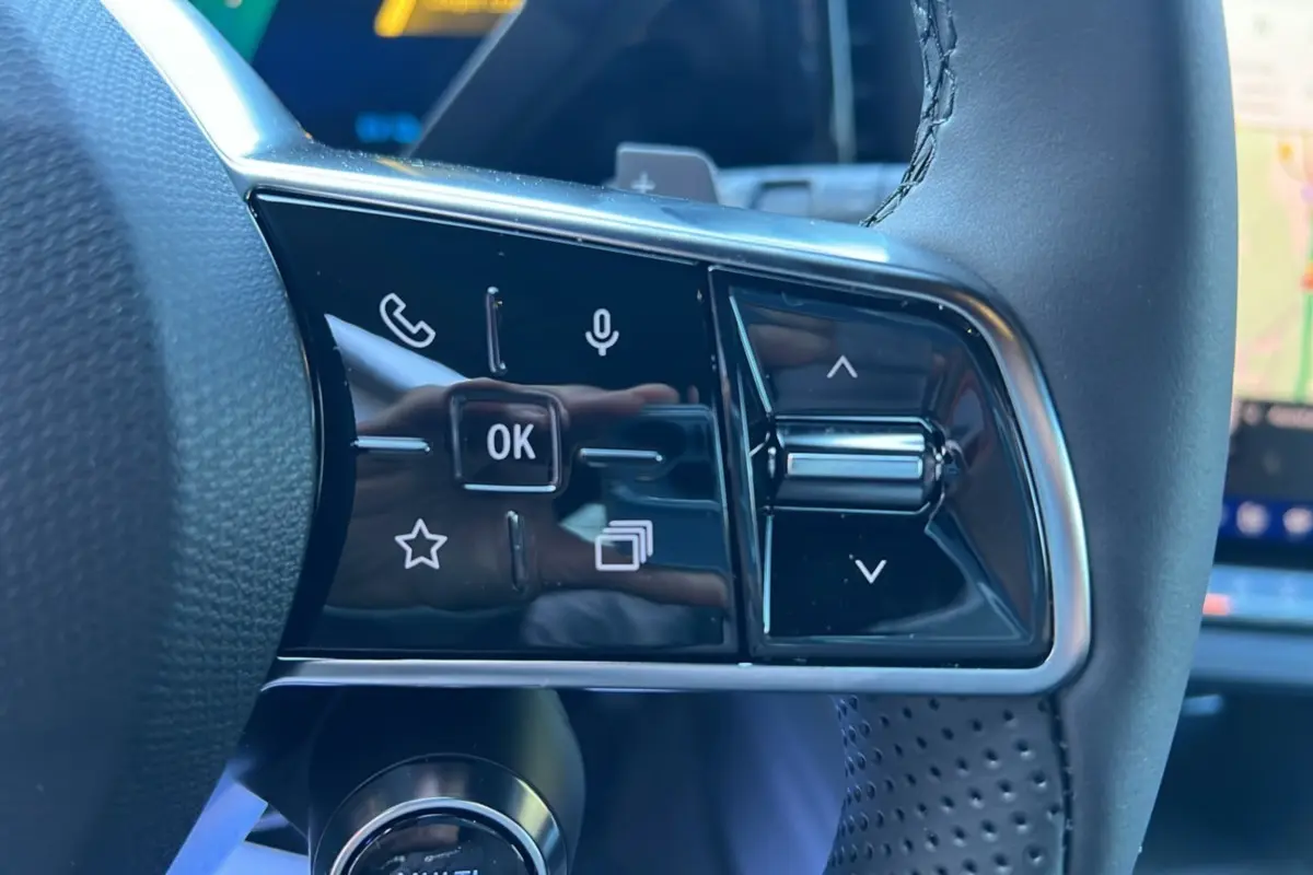 Gros plan sur les commandes tactiles du volant du Renault Austral E-Tech 200 Techno 2025 en cuir noir perforé.