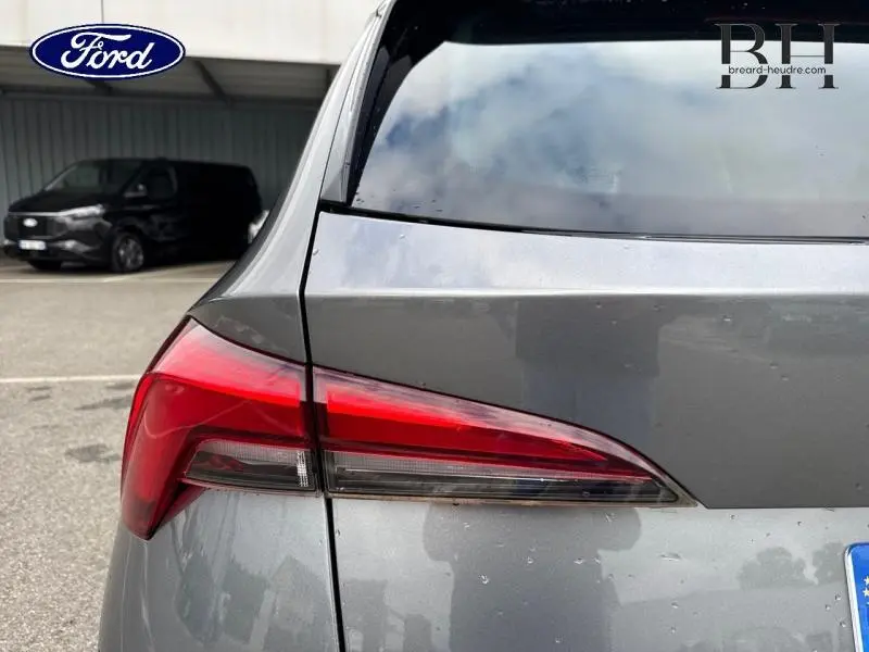 Gros plan sur le feu arrière gauche d'un SKODA KAMIQ gris graphite métallisé, soulignant la finition moderne du modèle 2023.