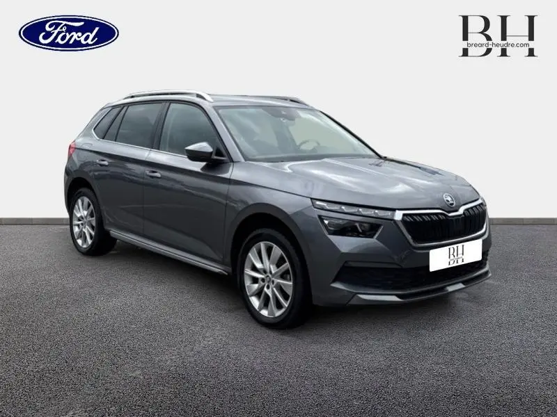 Vue 3/4 avant d'un Skoda Kamiq gris graphite métallisé avec calandre chromée et jantes alu visibles.