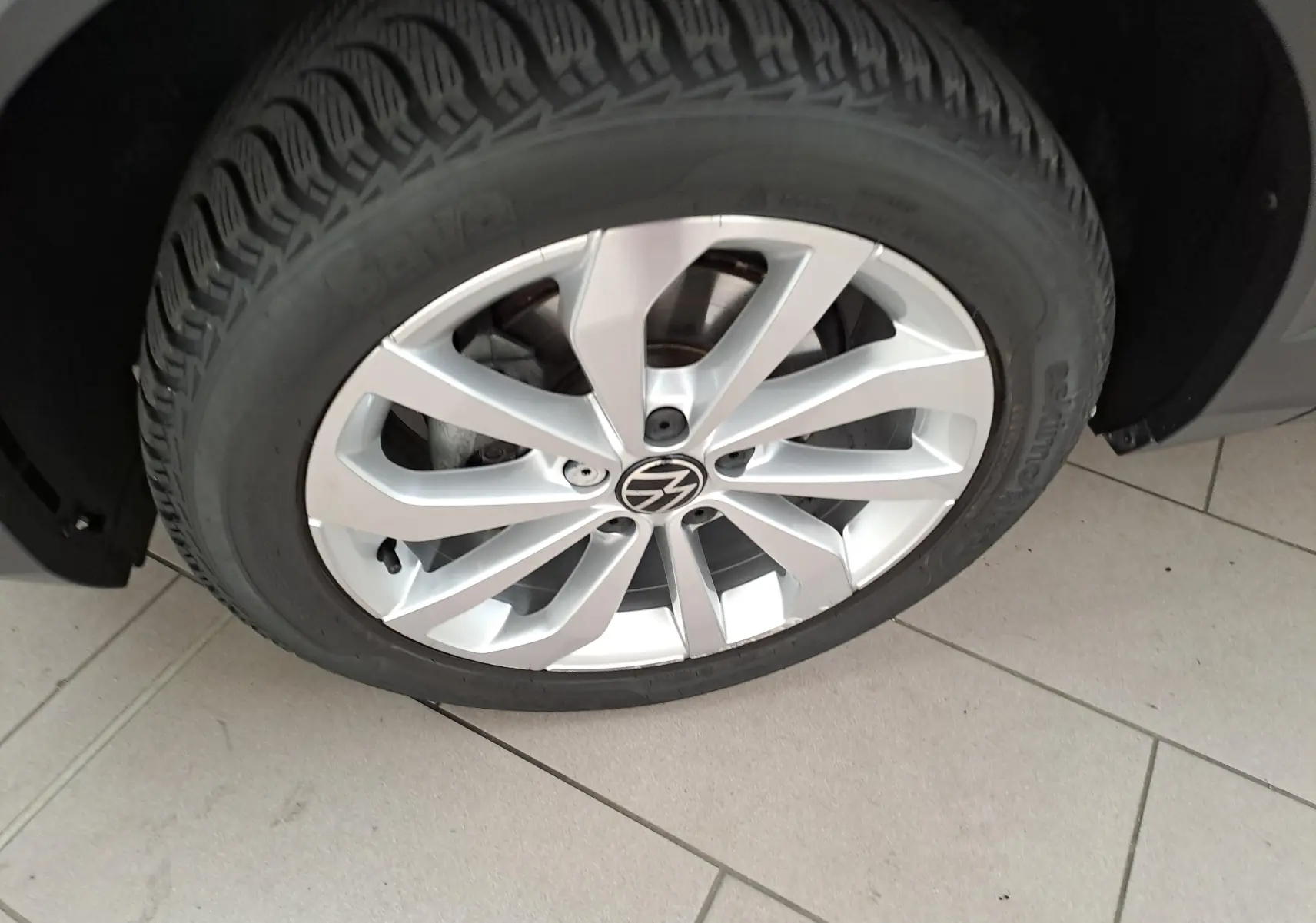 Gros plan sur la jante alliage 17'' Johannesburg d'un Volkswagen T-Roc gris Indium, roue avant droite visible.