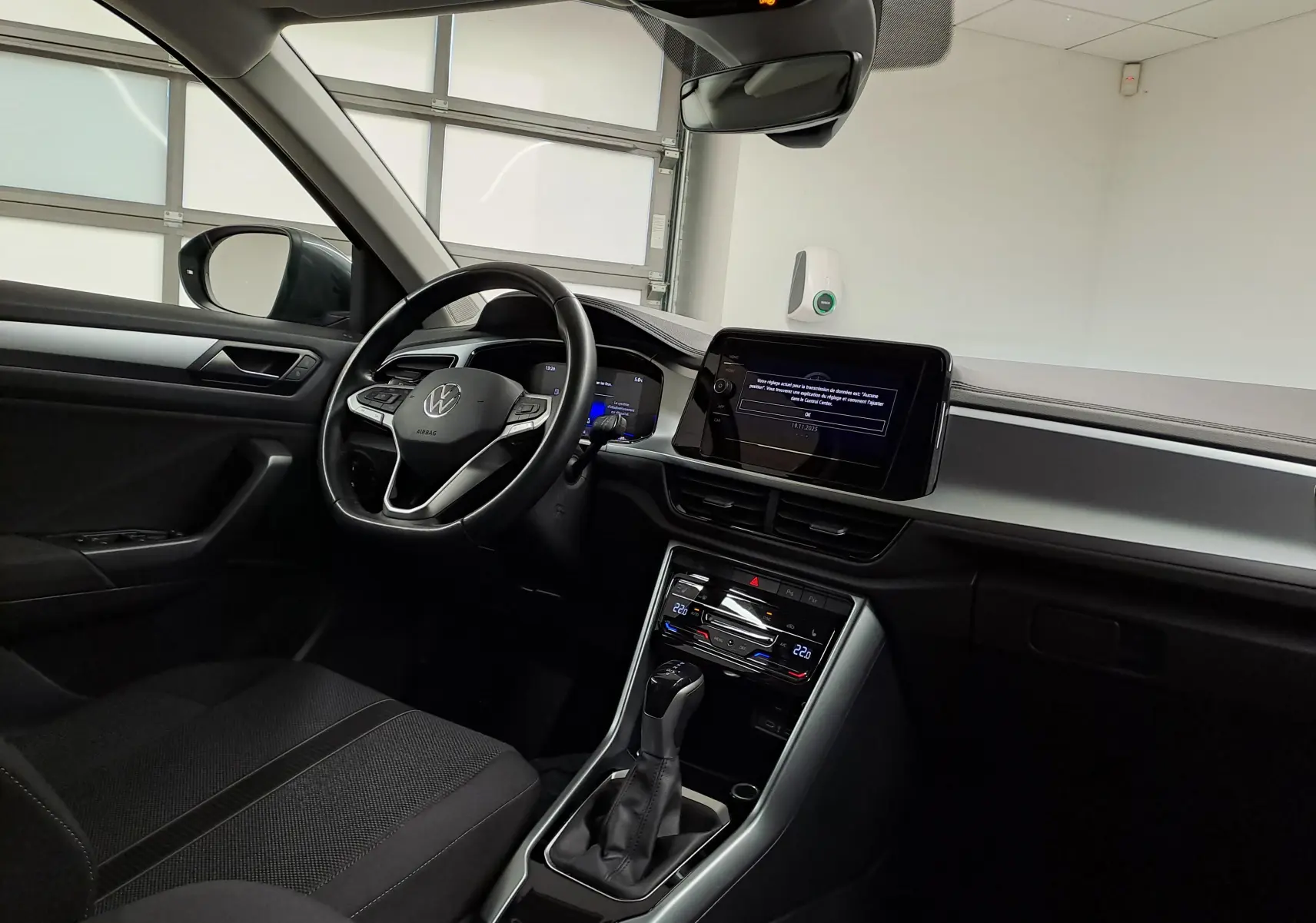 Vue intérieure côté conducteur du Volkswagen T-Roc 1.5 TSI 150 DSG7 LIFE avec tableau de bord moderne et écran tactile.