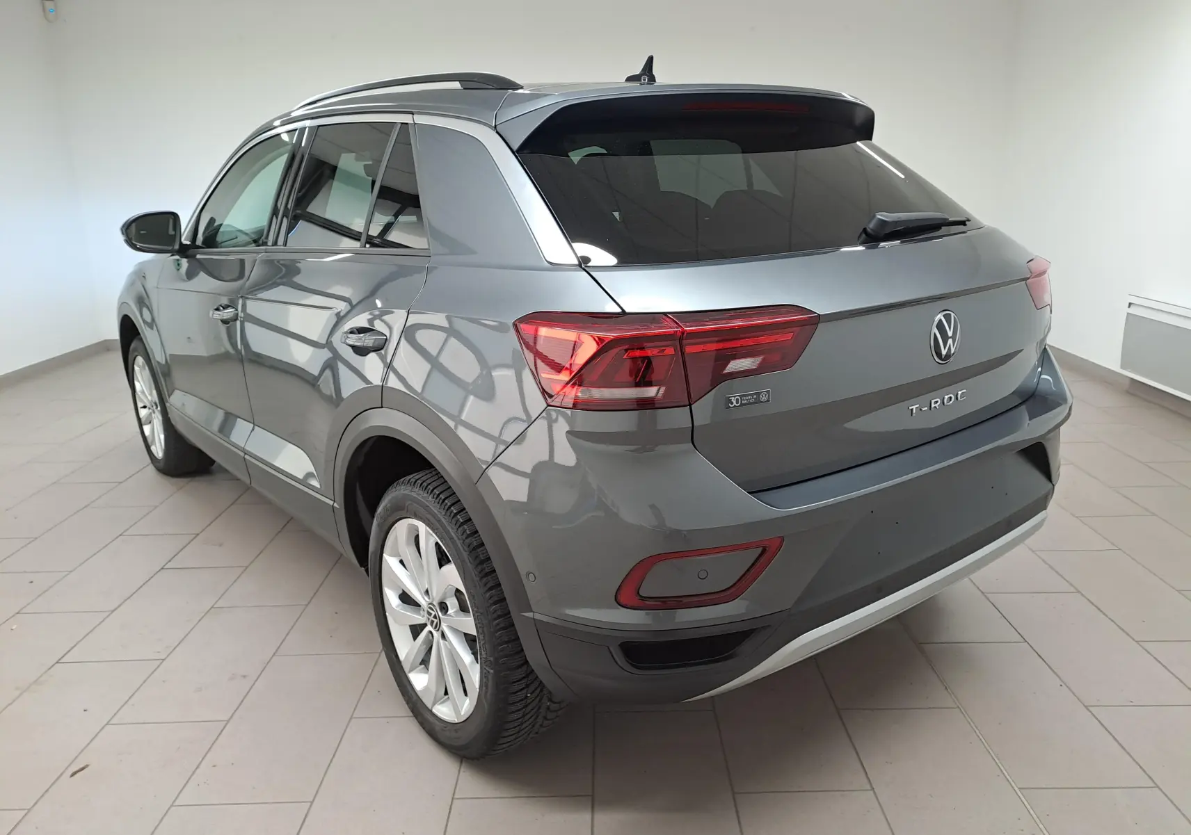 Volkswagen T-Roc gris Indium vu en 3/4 arrière droit, avec jantes alliage 17'' Johannesburg et caméra de recul.