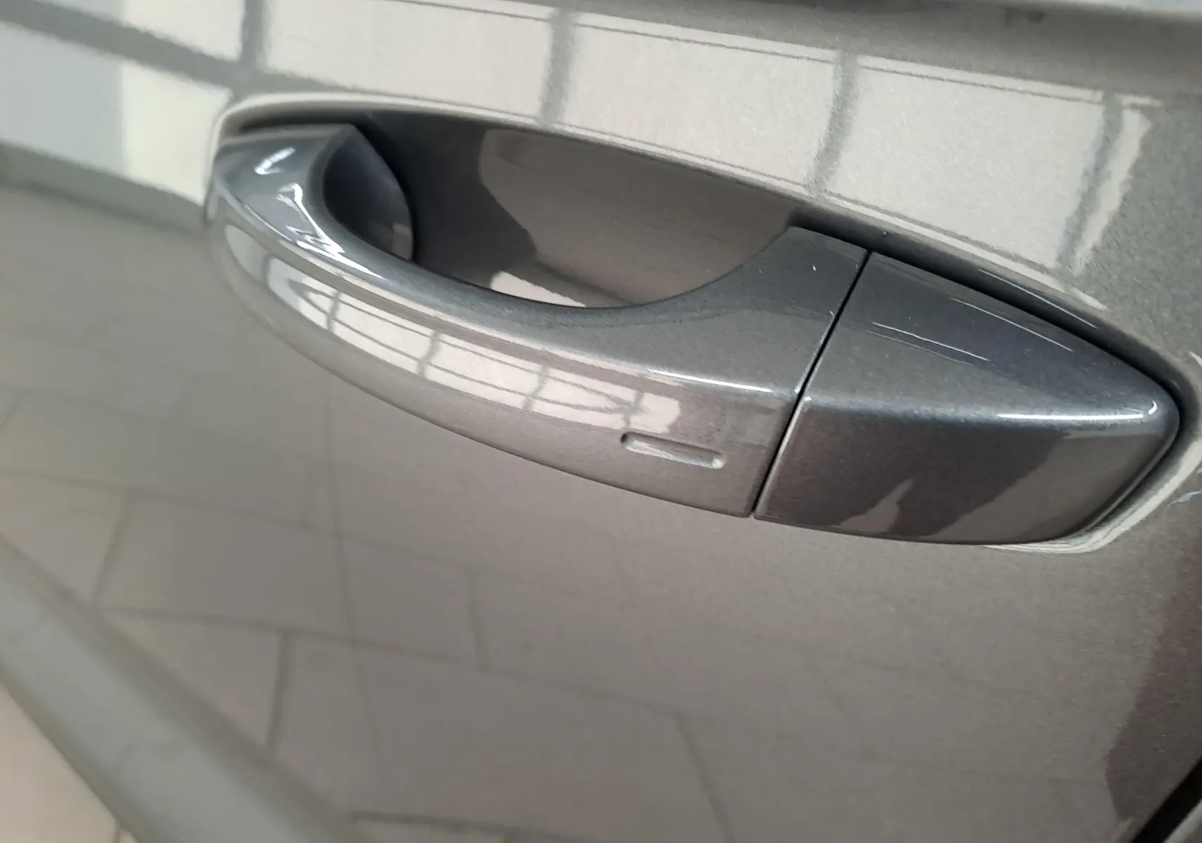 Poignée de porte côté gauche en gros plan sur Volkswagen T-Roc 2024 gris Indium métallisé.