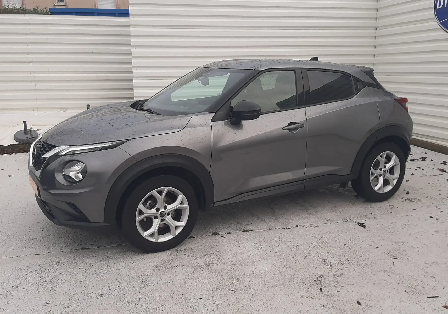 Nissan Juke gris 2020 en vue 3/4 avant droit, avec jantes alliage et détails noirs contrastants.