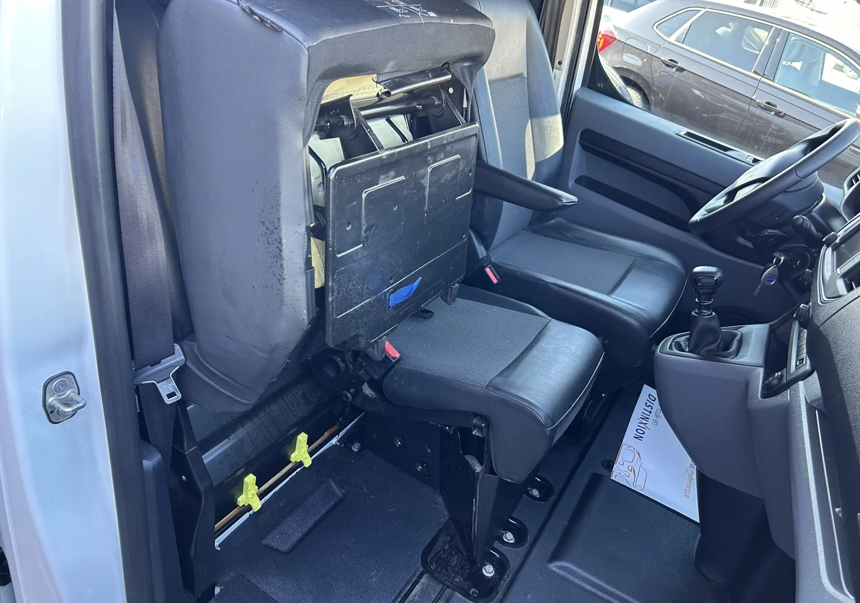 Vue intérieure côté conducteur du Citroën Jumpy blanc 2017, siège passager relevé avec tablette intégrée.