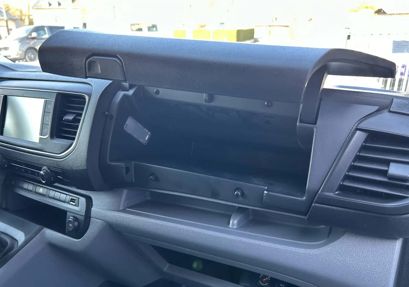 Intérieur du Citroën Jumpy 2017, vue sur la boîte à gants ouverte côté passager avec tableau de bord noir.