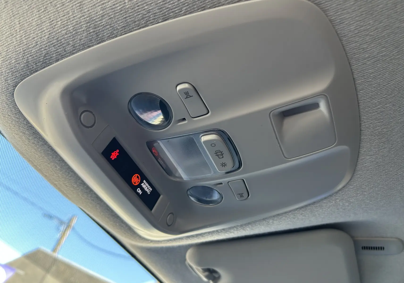 Plafonnier intérieur gris avec commandes d’éclairage et indicateur d’airbag visible dans un Citroën Jumpy blanc.