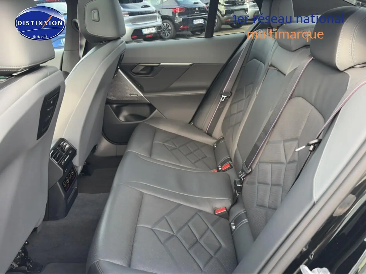 Vue intérieure arrière côté droit de la BMW Série 5 i5 M60 2024 avec sièges cuir noirs et surpiqûres contrastées.