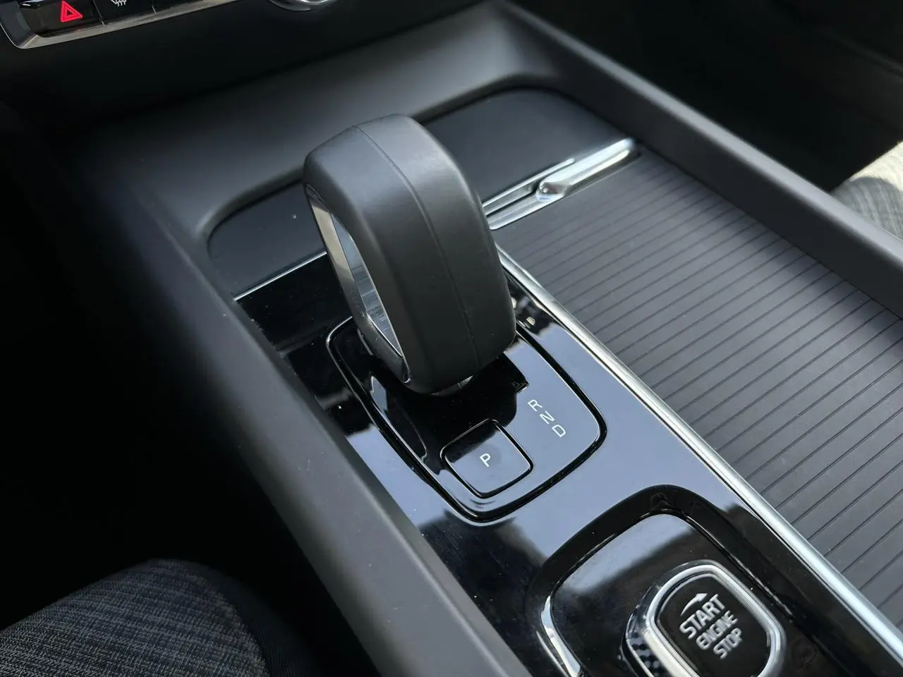 Gros plan sur le levier de vitesses automatique et bouton start/stop de la console centrale d'une Volvo S60 gris Platinium.