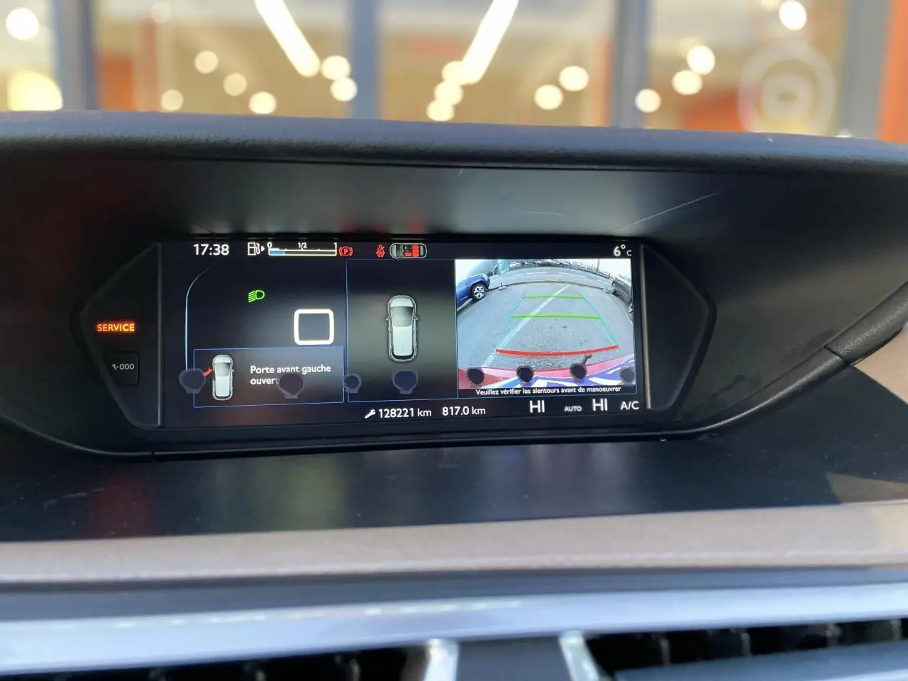 Écran central de la Citroën C4 Picasso rouge foncé affichant la caméra de recul et l'ouverture de la porte avant gauche.