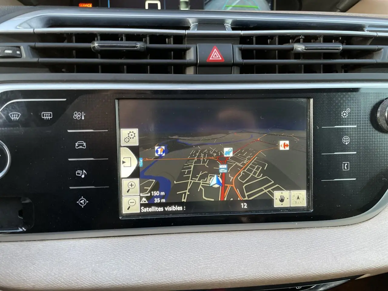 Tablette tactile de navigation affichant une carte dans l'habitacle d'une Citroën C4 Picasso rouge foncé, vue intérieure.