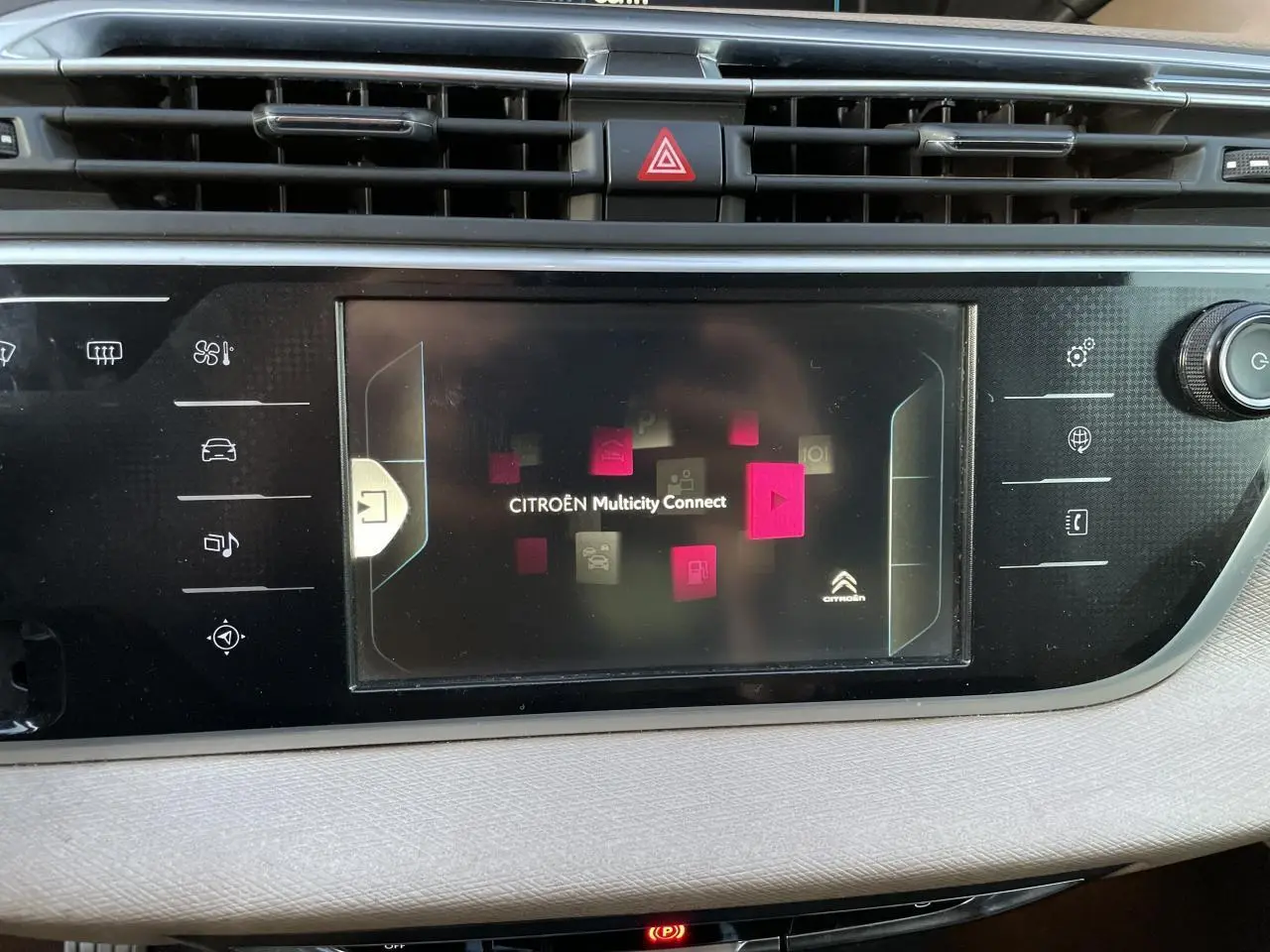 Écran tactile central du tableau de bord de la Citroën C4 Picasso rouge foncé, affichant le menu Multicity Connect.