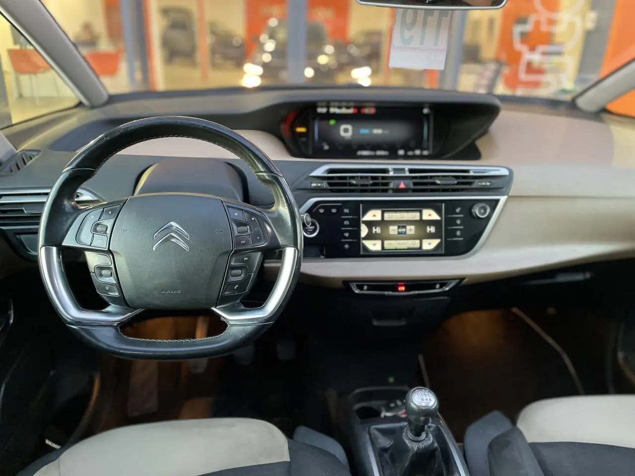 Intérieur du Citroën C4 Picasso 2014 avec volant multifonction, tableau de bord moderne et levier de vitesse manuel.