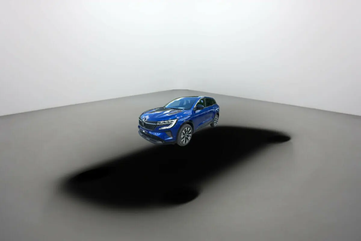 Renault Austral E-Tech 200 Techno Tpano 2025 bleu iron en 3/4 avant droit sur fond neutre avec ombre marquée.