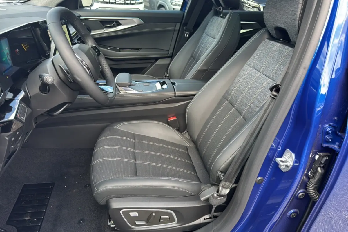 Intérieur côté conducteur du Renault Austral E-Tech 200 en bleu iron, sièges tissu et cuir avec réglages électriques.