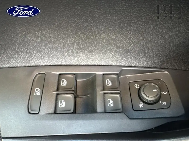 Gros plan sur les commandes de lève-vitres et rétroviseurs côté conducteur du Volkswagen Taigo blanc 2024.