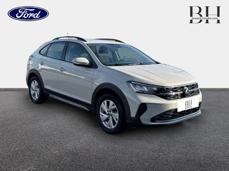 Volkswagen Taigo blanc pur en 3/4 avant droit avec jantes alu et barres de toit visibles