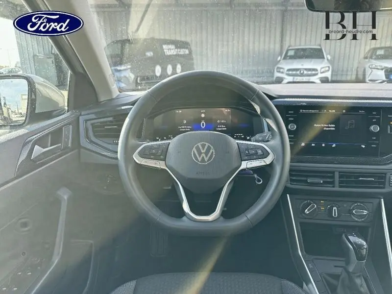 Vue frontale de l'intérieur du Volkswagen Taigo 2024 avec volant cuir multifonction et écran tactile central.