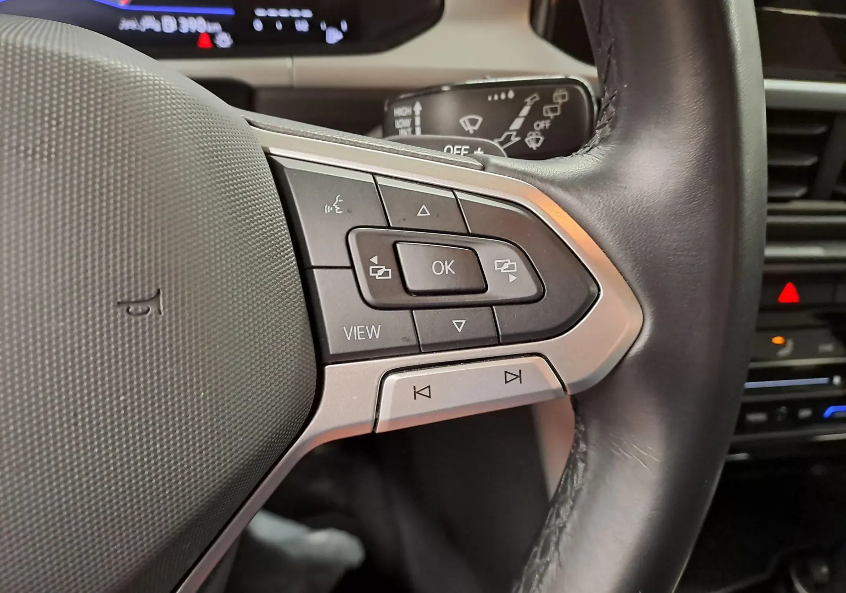 Gros plan sur les commandes au volant du Volkswagen T-Roc 2024, avec boutons multifonctions et volant cuir noir.