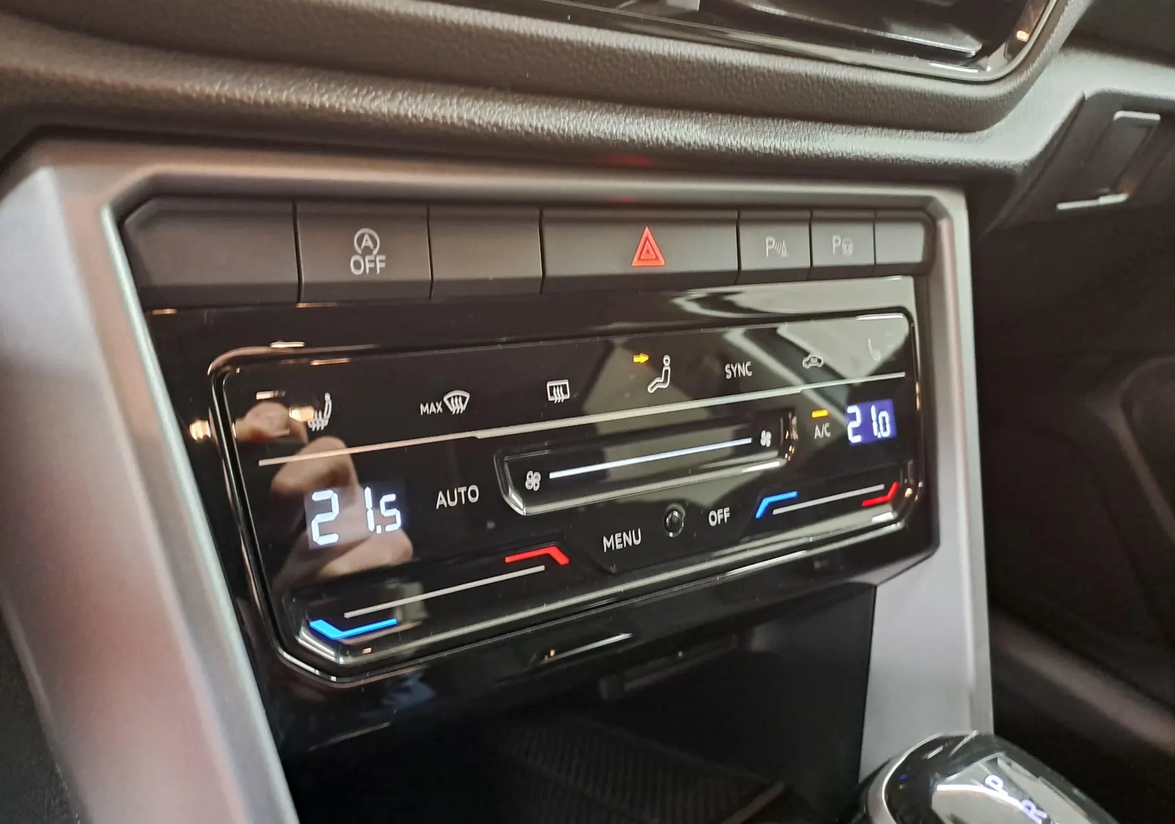 Détail de la console centrale du Volkswagen T-Roc 2024 avec commandes climatisation numériques et finition noire brillante.