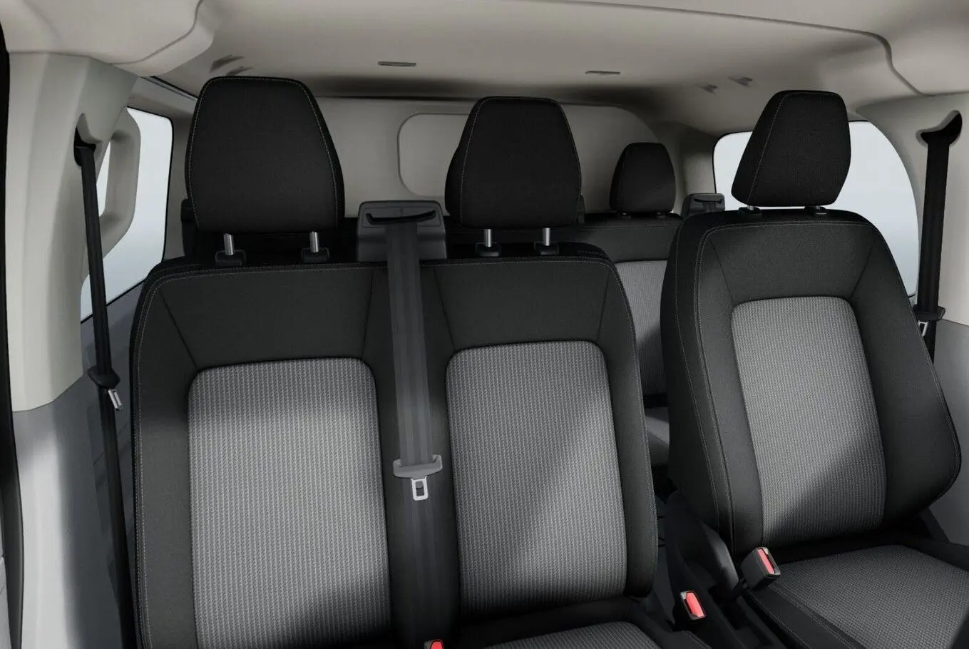 Vue intérieure sur les sièges avant et arrière en tissu gris et noir du Volkswagen Transporter ProCab T7 2025.