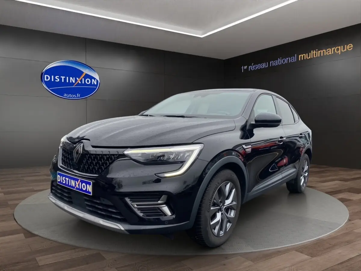 Renault Arkana noir vue 3/4 avant droit avec feux LED et calandre noire brillante dans showroom.