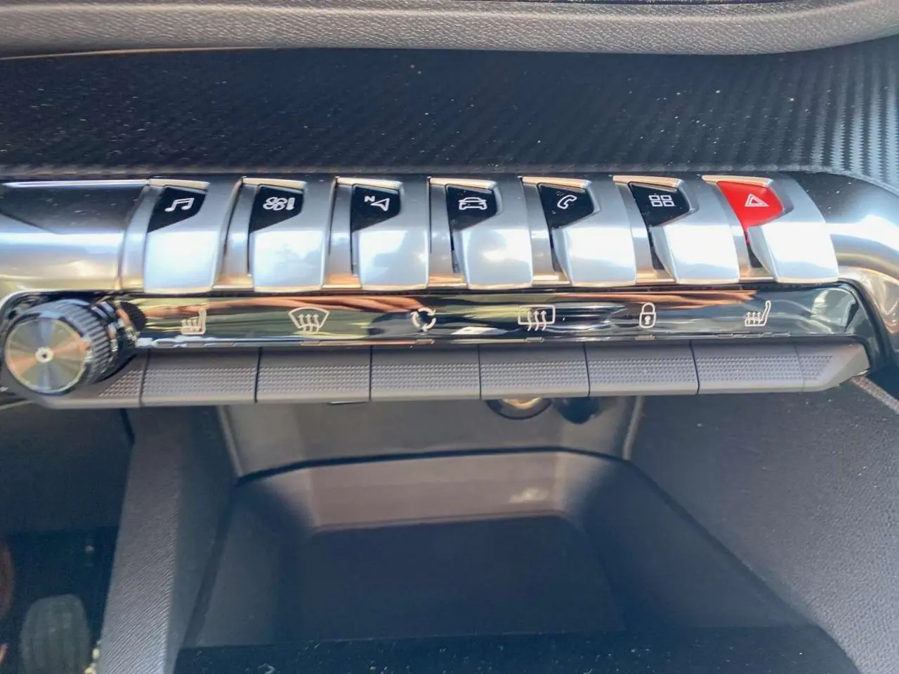 Gros plan sur la rangée de boutons de commande argentés et noirs du tableau de bord du Peugeot 3008 2023.