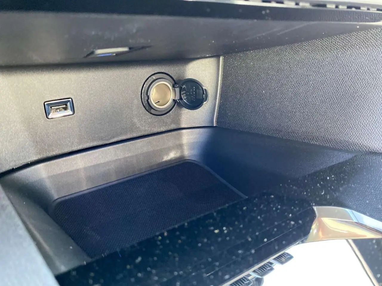 Prise allume-cigare et port USB dans le rangement central avant du Peugeot 3008 gris platinium 2023.