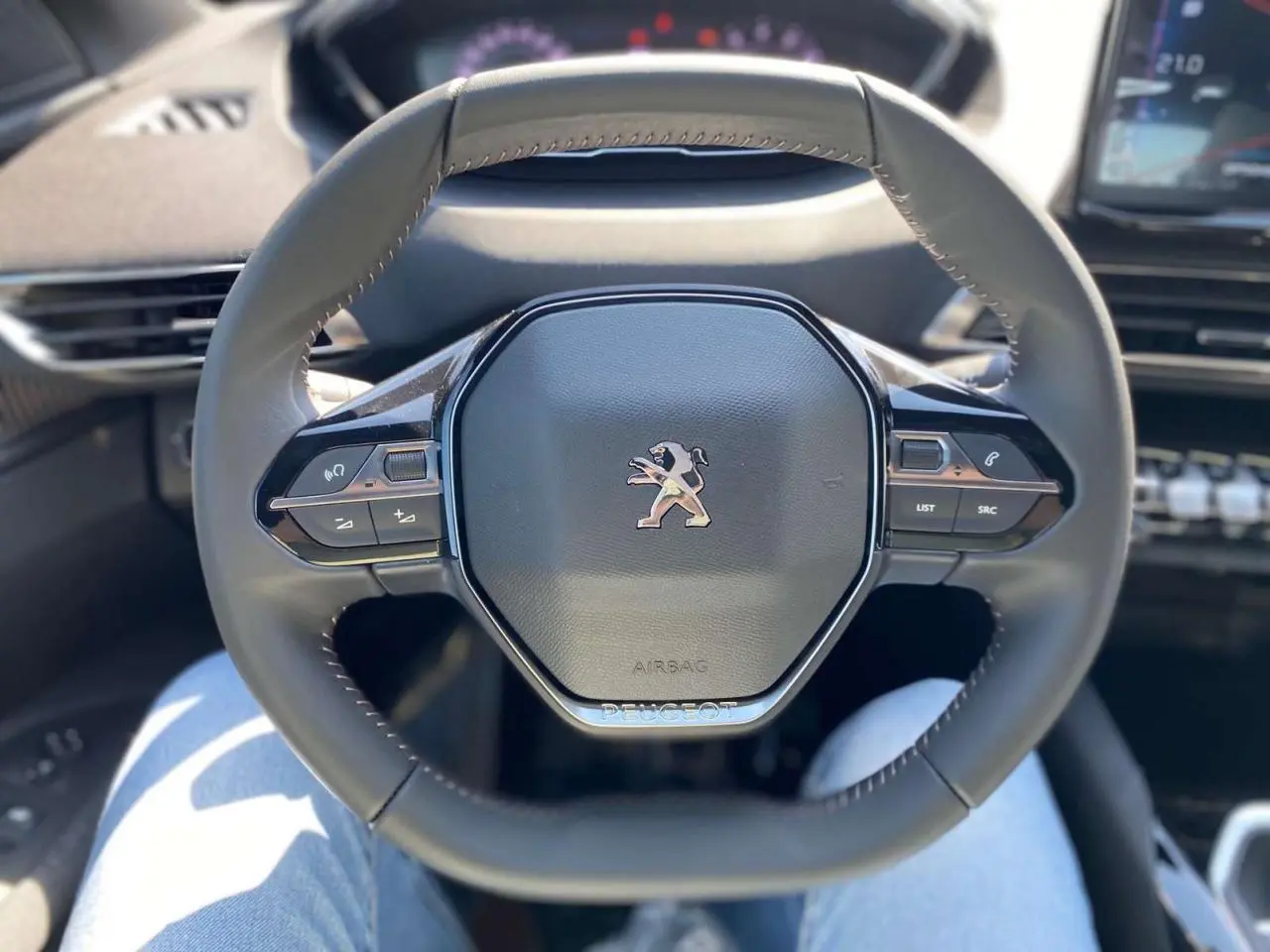 Volant compact multifonctions du Peugeot 3008 2023, vue frontale centrée sur le logo lion et commandes intégrées.