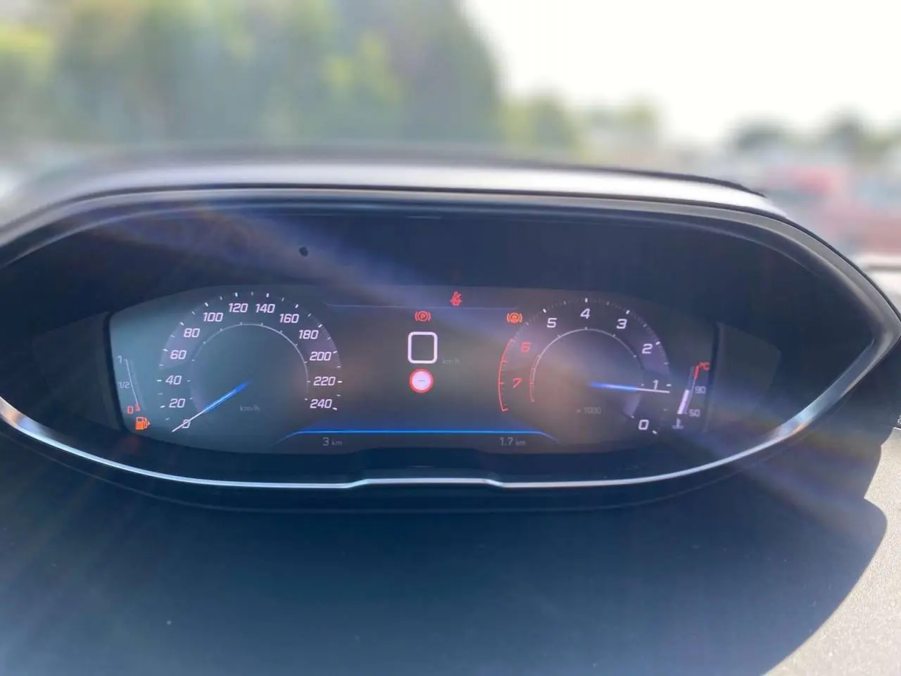 Tableau de bord numérique Peugeot 3008 2023 affichant la vitesse et le régime moteur au soleil.