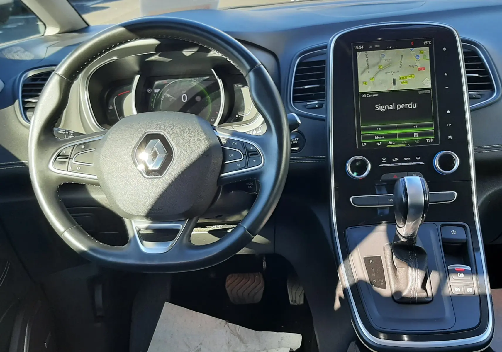 Intérieur noir du Renault Scenic IV essence, vue du poste de conduite avec écran tactile central et levier de boîte automatique.