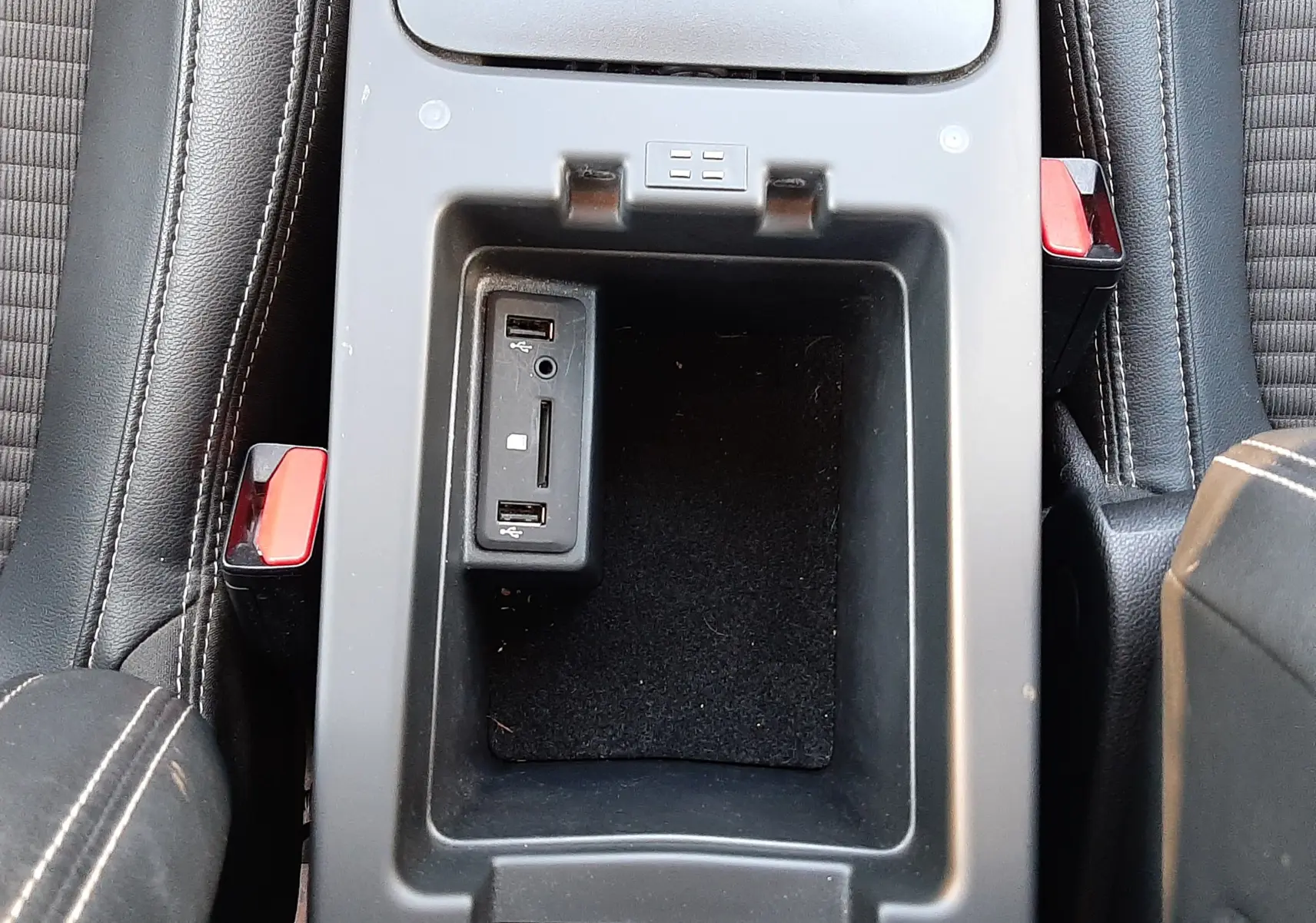 Vue plongeante sur la console centrale noire du Renault Scenic IV, avec ports USB et lecteur carte SD intégrés.