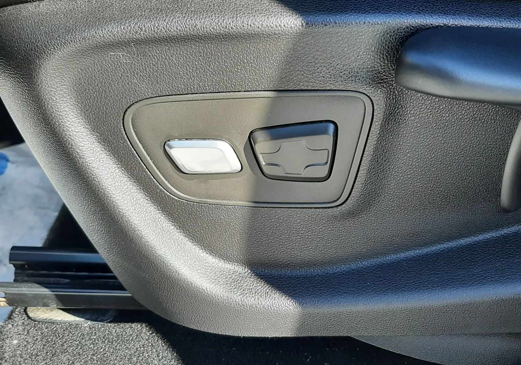 Commandes électriques de réglage du siège en gros plan sur un Renault Scenic IV blanc nacré.